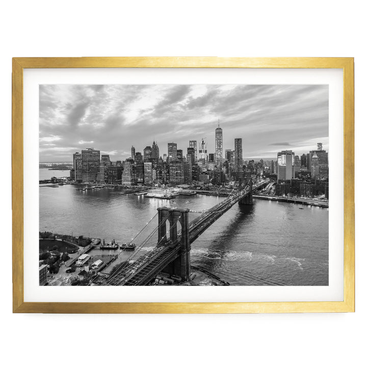 A black and white aerial view of the New York City skyline, featuring the Brooklyn Bridge and the surrounding cityscape.