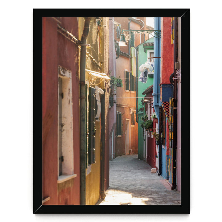 A narrow, colorful alleyway in a city, with buildings painted in various vibrant colors lining the sides.