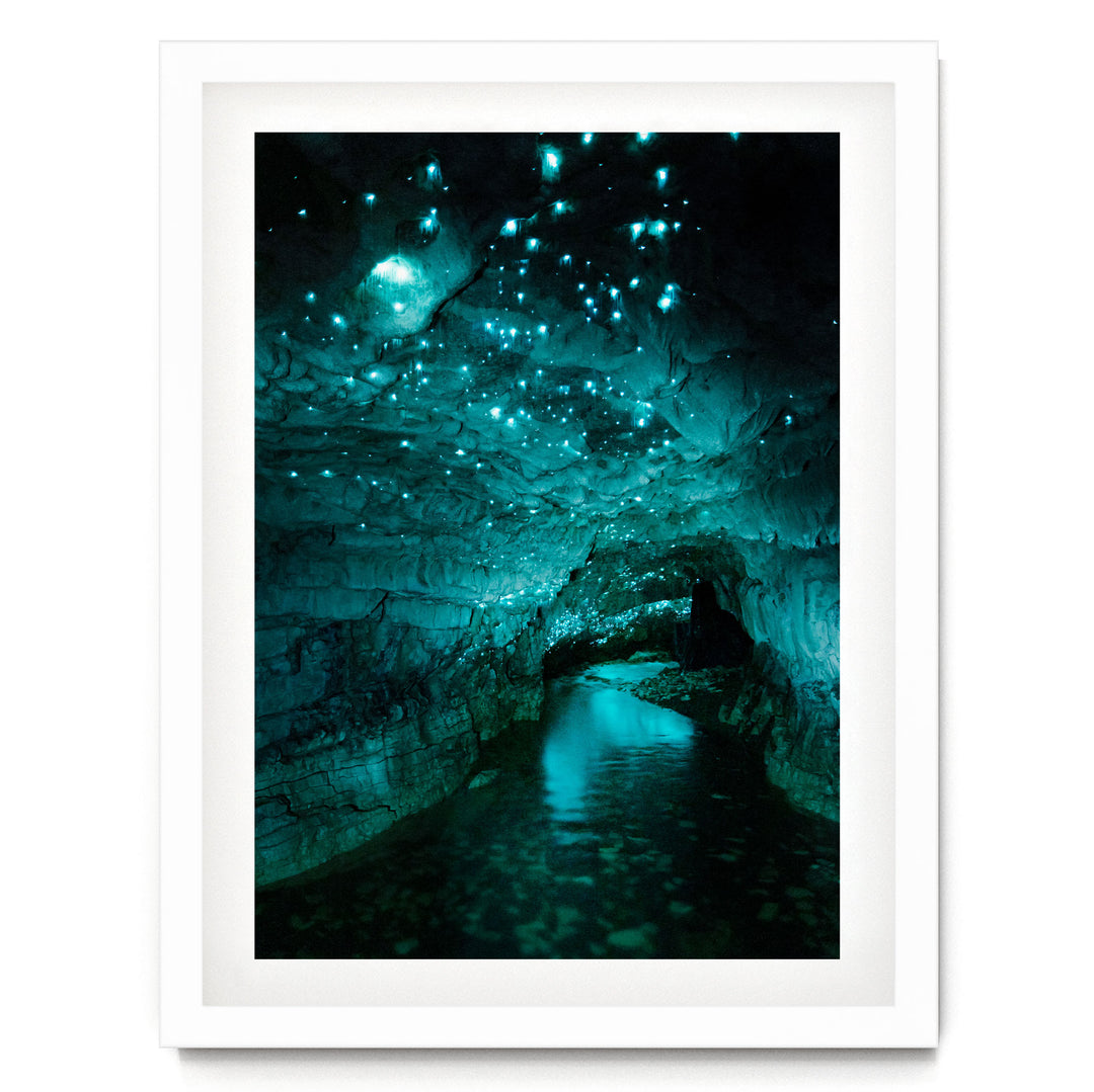 A stunning cave with a pool of water at its center, surrounded by a mesmerizing display of glowing blue and green lights that illuminate the cave's interior.