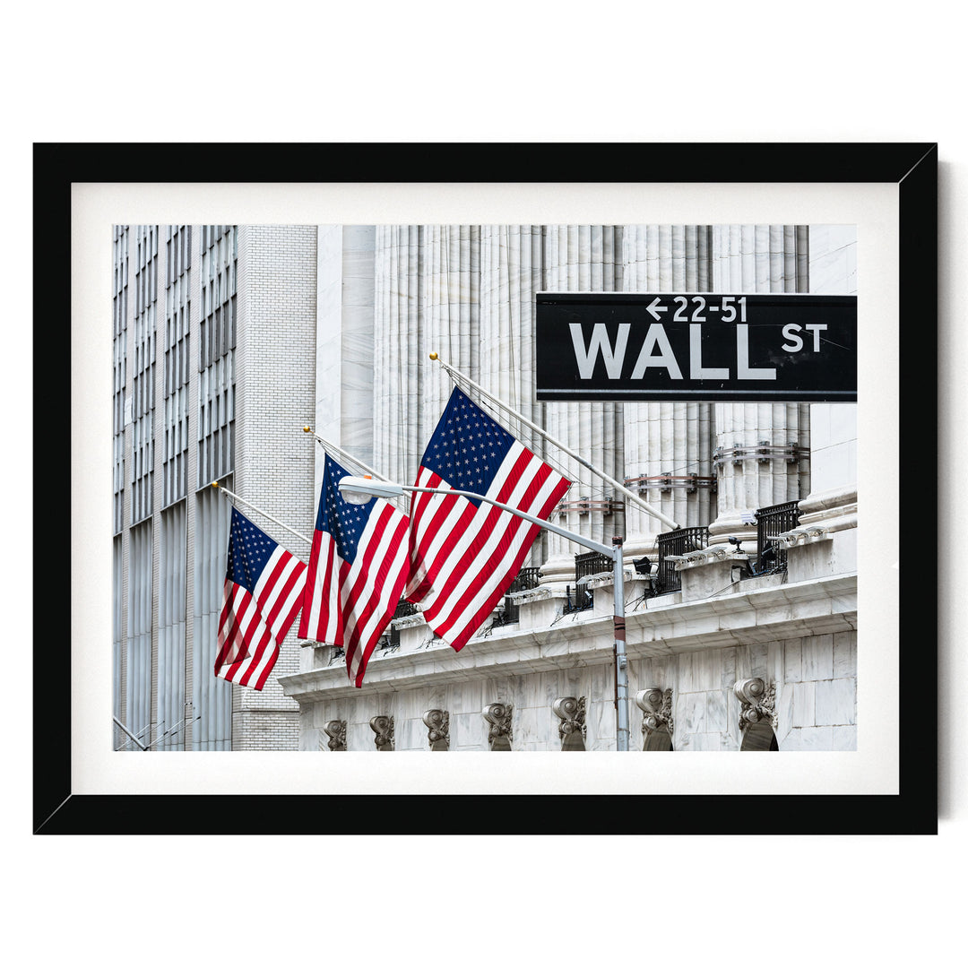 a framed photograph of the Wall Street building with three American flags flying in front of it.