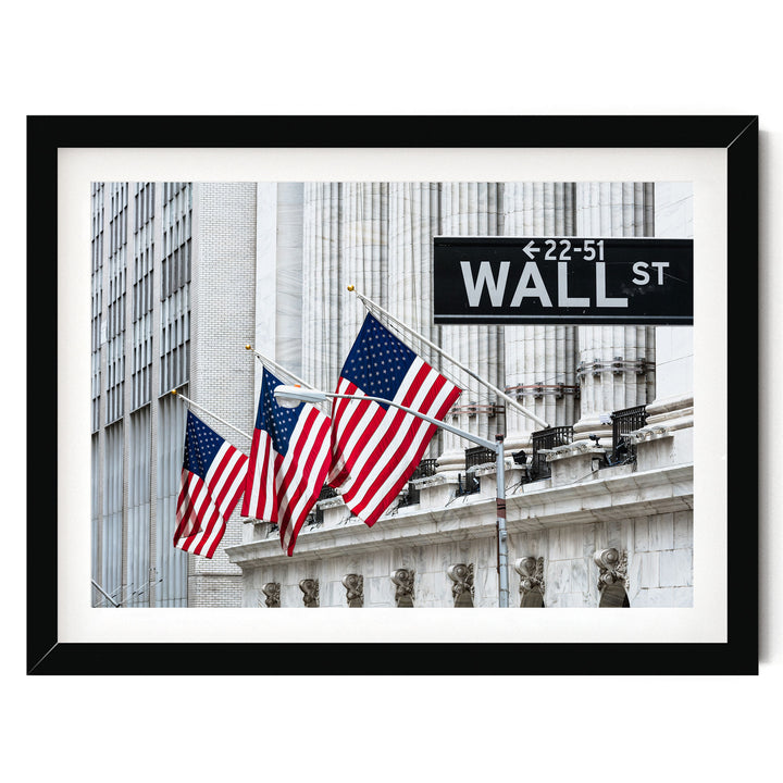 a framed photograph of the Wall Street building with three American flags flying in front of it.