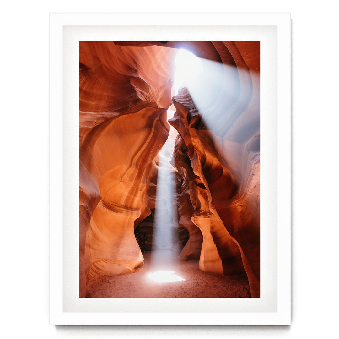 a stunning natural rock formation with a bright light shining through the narrow passage, creating a dramatic and captivating scene.