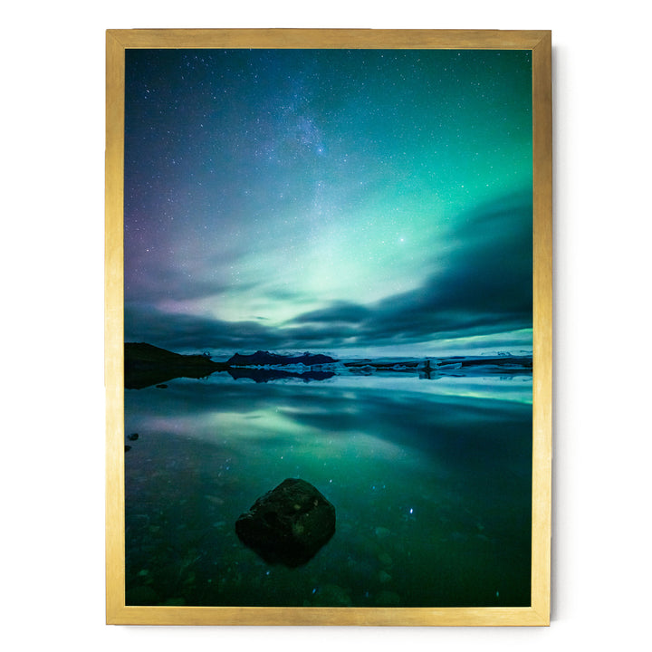 a serene night scene with a starry sky reflected in a calm body of water, surrounded by mountains.