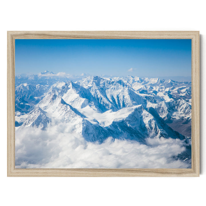 a breathtaking view of snow-capped mountains rising majestically from a cloudy sky, creating a serene and awe-inspiring landscape.