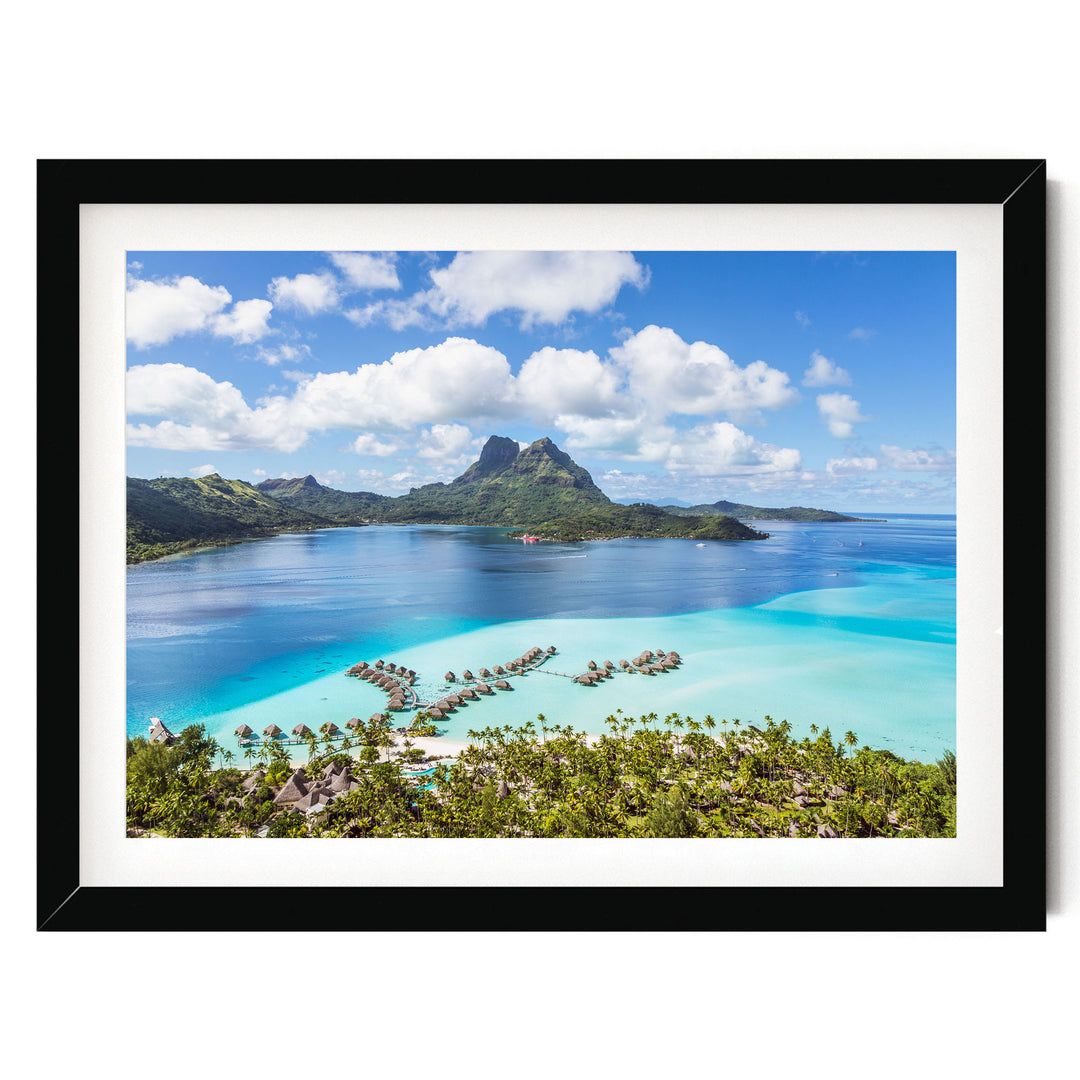 A framed image depicting a tropical island with a clear blue sky, turquoise waters, and lush green vegetation surrounding it.