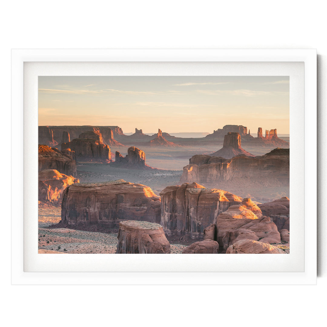 a breathtaking view of the Grand Canyon, with its vast, rugged landscape stretching out as far as the eye can see. The canyon's towering rock formations and dramatic cliffs are illuminated by the warm, golden light of the setting sun, creating a stunning and awe-inspiring scene.