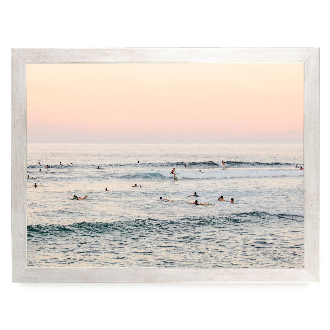 a group of people enjoying themselves in the ocean, with some of them riding waves on surfboards.