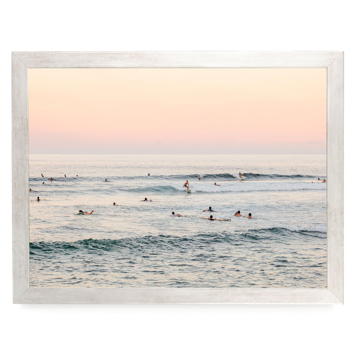 a group of people enjoying themselves in the ocean, with some of them riding waves on surfboards.