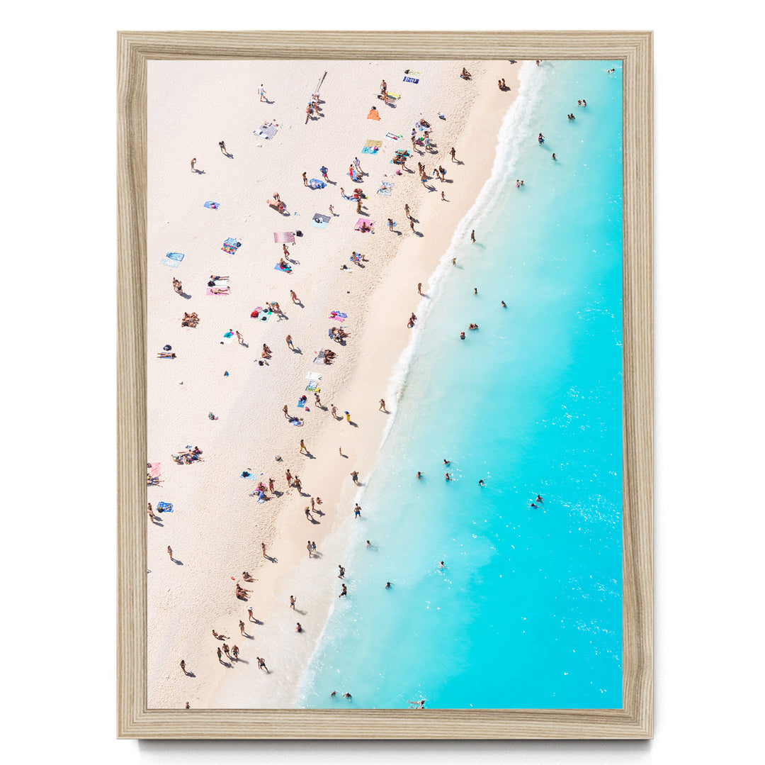a crowded beach with people enjoying the sun and sand, with the ocean visible in the background.