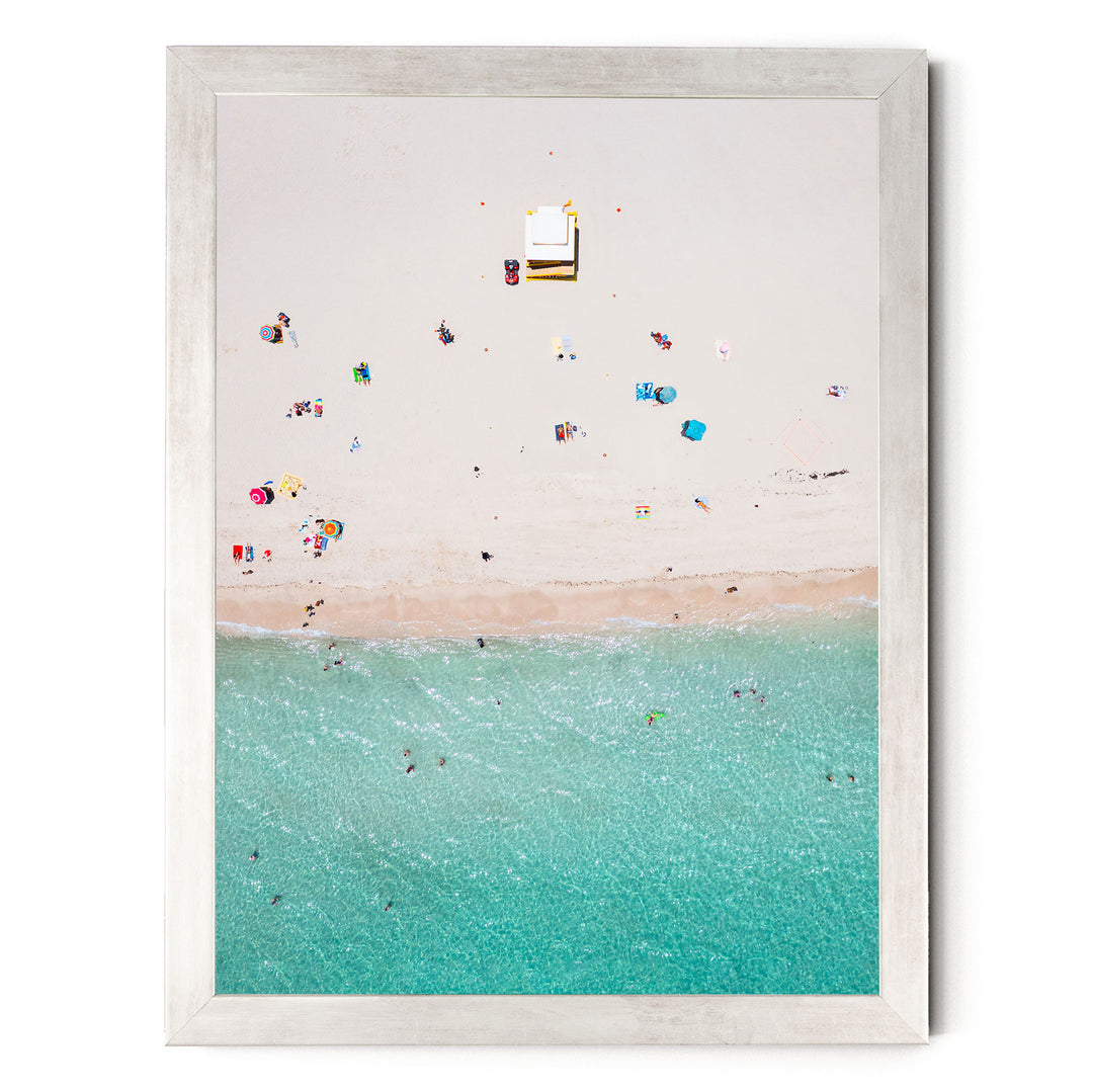 a beach scene with people enjoying the sun and water, featuring a variety of colorful umbrellas and beach chairs scattered across the sandy shore.