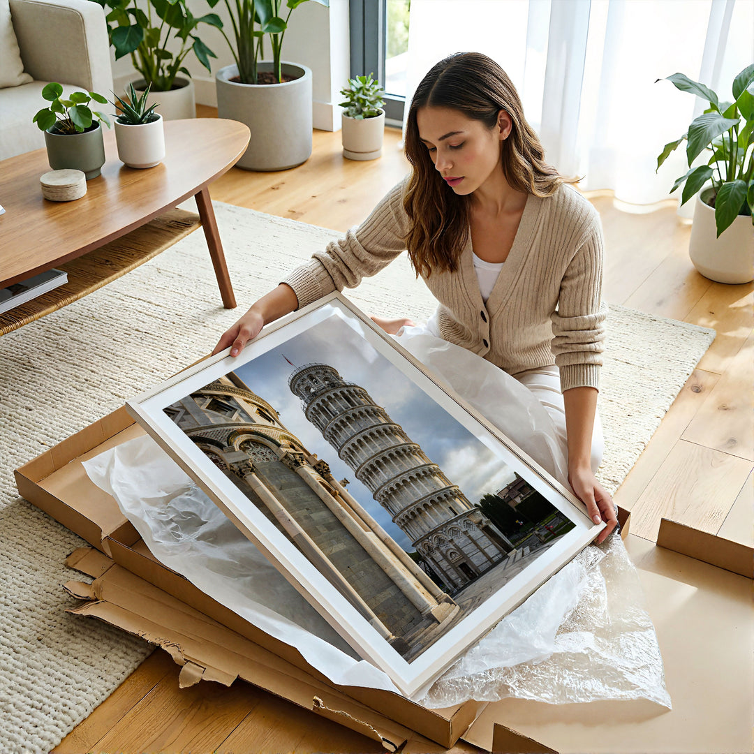 Woman unboxing a framed Leaning Tower of Pisa print at home