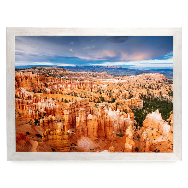 a breathtaking view of the rugged, orange rock formations of Bryce Canyon National Park, with a dramatic sky and clouds in the background.