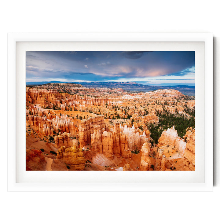 a breathtaking view of the rugged, orange rock formations of Bryce Canyon National Park, with a dramatic sky and clouds in the background.