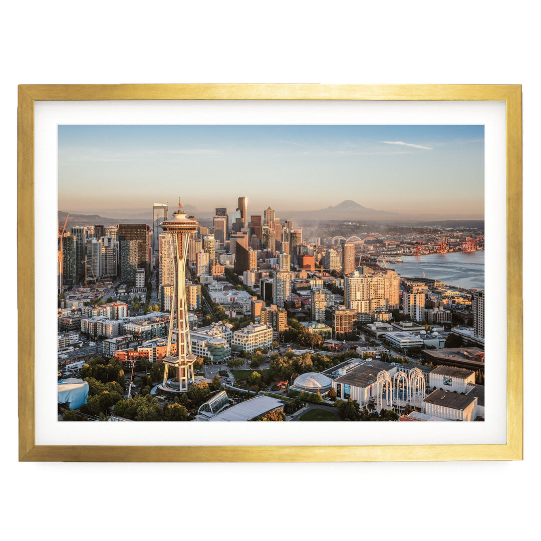 The image is a panoramic view of the Seattle skyline, showcasing the iconic Space Needle and the surrounding cityscape.