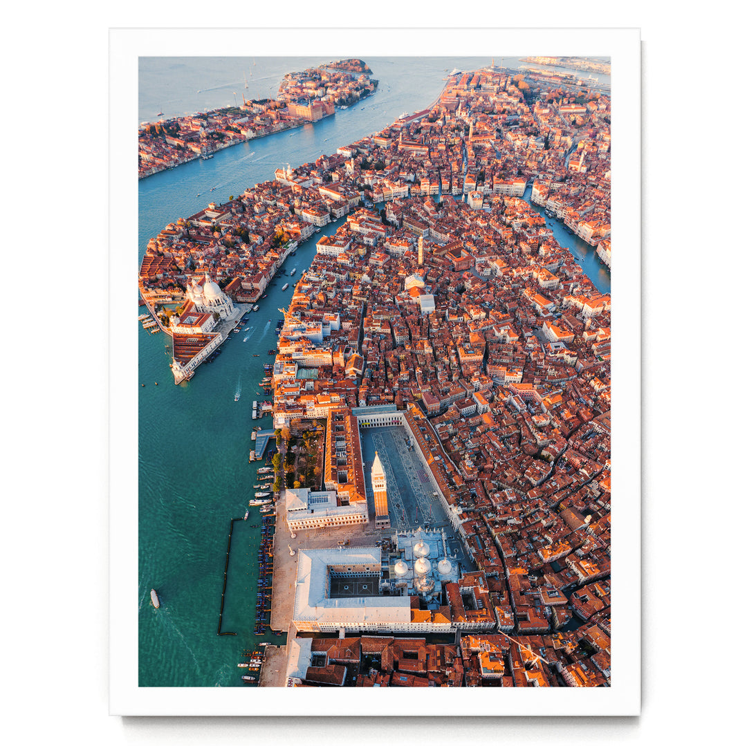 An aerial view of the city of Venice, Italy, showcasing its iconic canals, domes, and buildings along the water's edge.