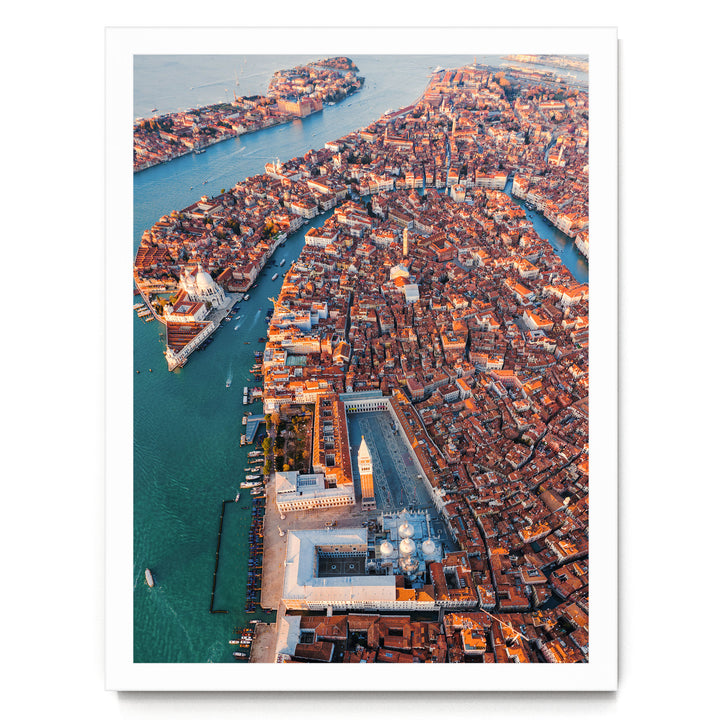 An aerial view of the city of Venice, Italy, showcasing its iconic canals, domes, and buildings along the water's edge.