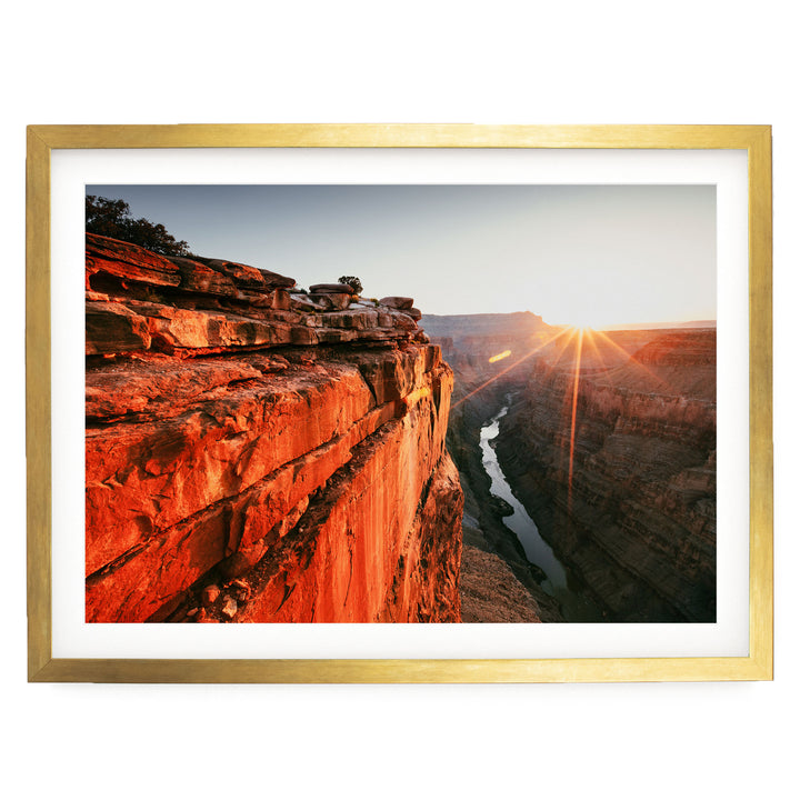 a breathtaking view of a canyon with a river flowing through it, set against a stunning sunset sky.