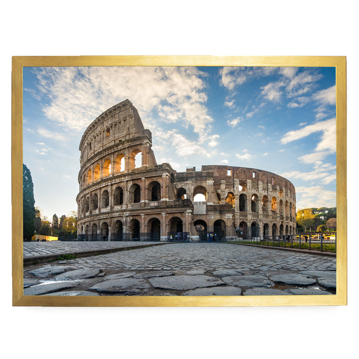 the Colosseum, an ancient amphitheater in Rome, Italy, with its distinctive oval shape and arches. The Colosseum is set against a backdrop of a blue sky with white clouds, creating a picturesque scene.