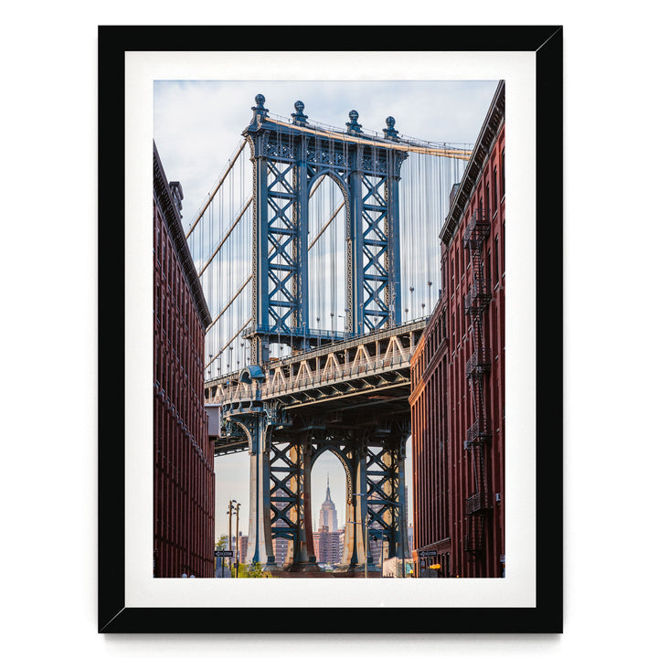 a large suspension bridge with multiple towers and cables, spanning across a street with buildings on either side.