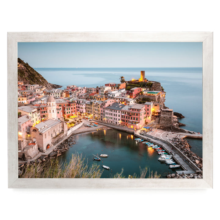 a picturesque coastal town with colorful buildings, a harbor filled with boats, and a lighthouse on a cliff overlooking the water.