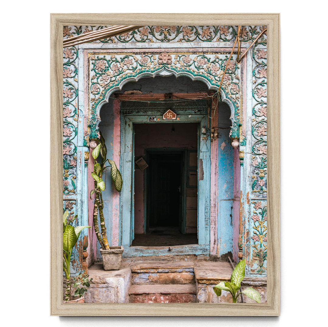a colorful, ornate doorway with intricate carvings and decorations, surrounded by lush greenery and plants.