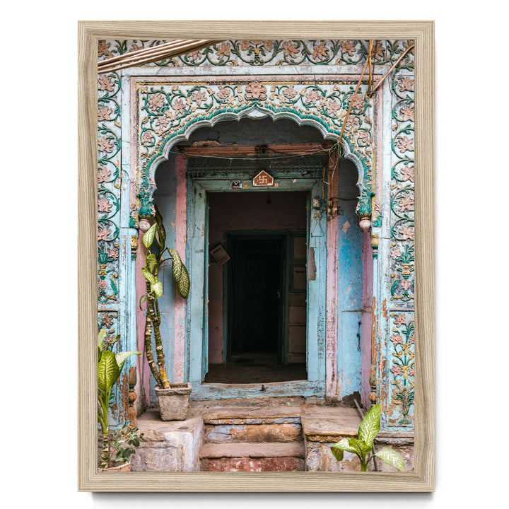 a colorful, ornate doorway with intricate carvings and decorations, surrounded by lush greenery and plants.