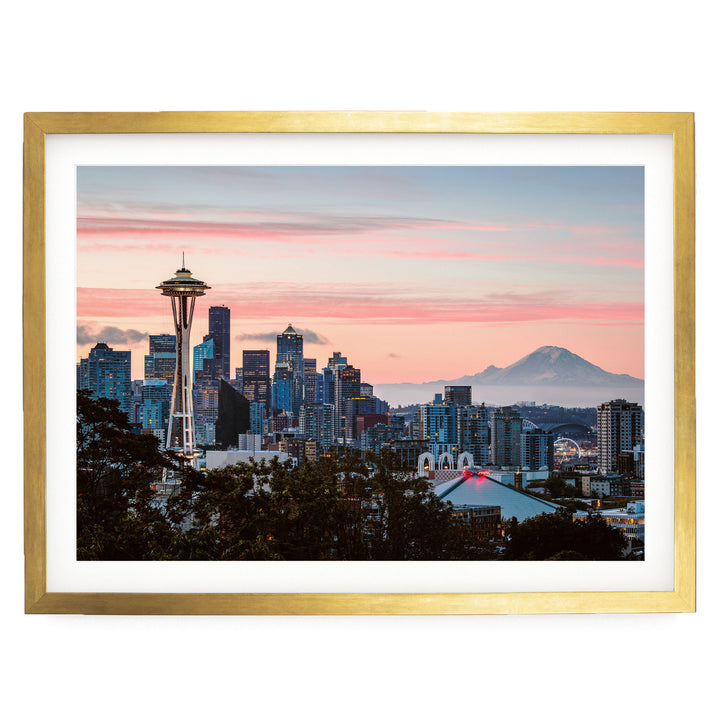 a city skyline at sunset, with the iconic Space Needle in the foreground and a mountain in the background.