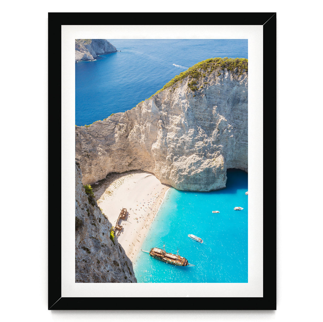 a picturesque coastal scene with a rocky cliff overlooking a turquoise sea dotted with boats.