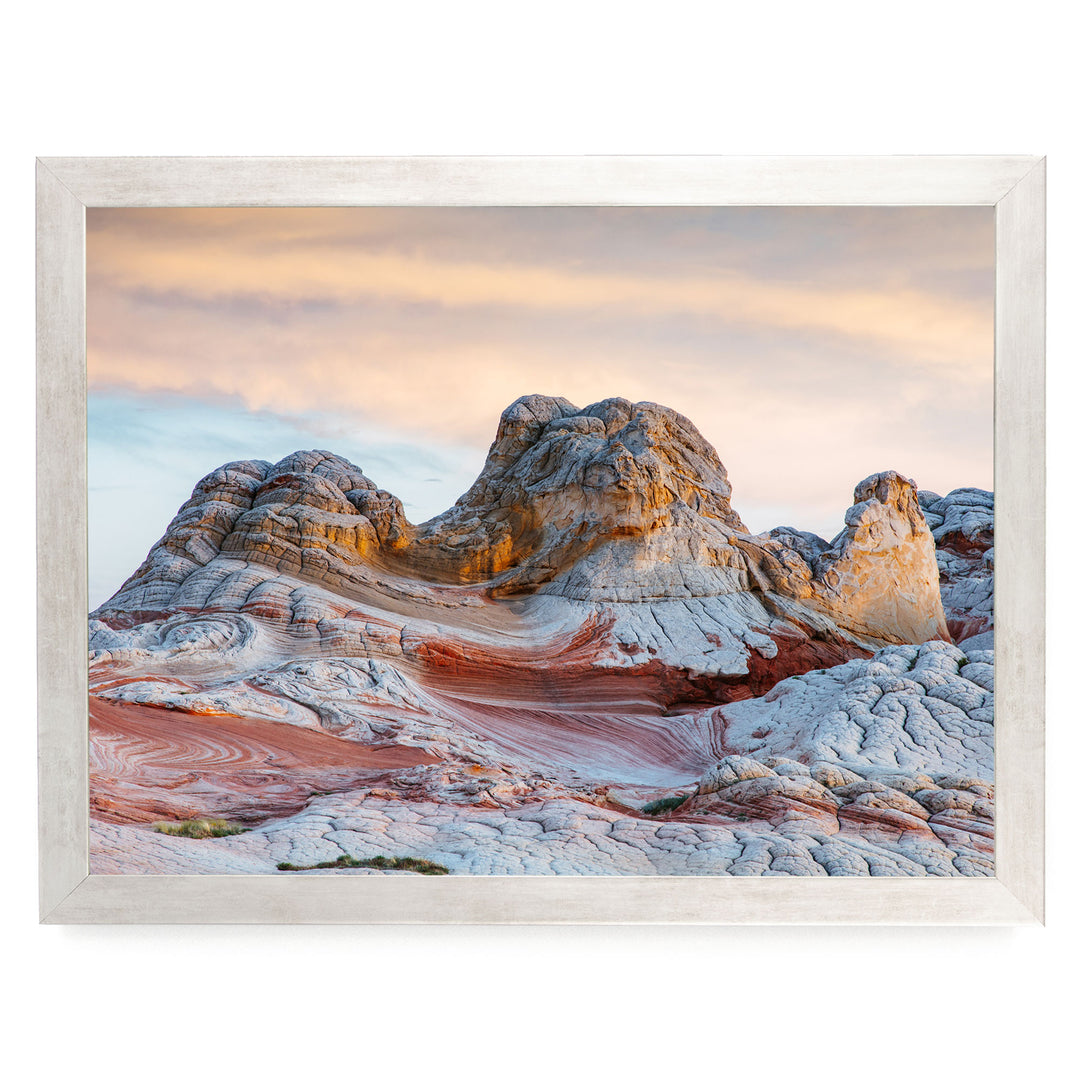 a striking natural landscape with a large, multi-colored rock formation in the foreground, set against a backdrop of a cloudy sky.
