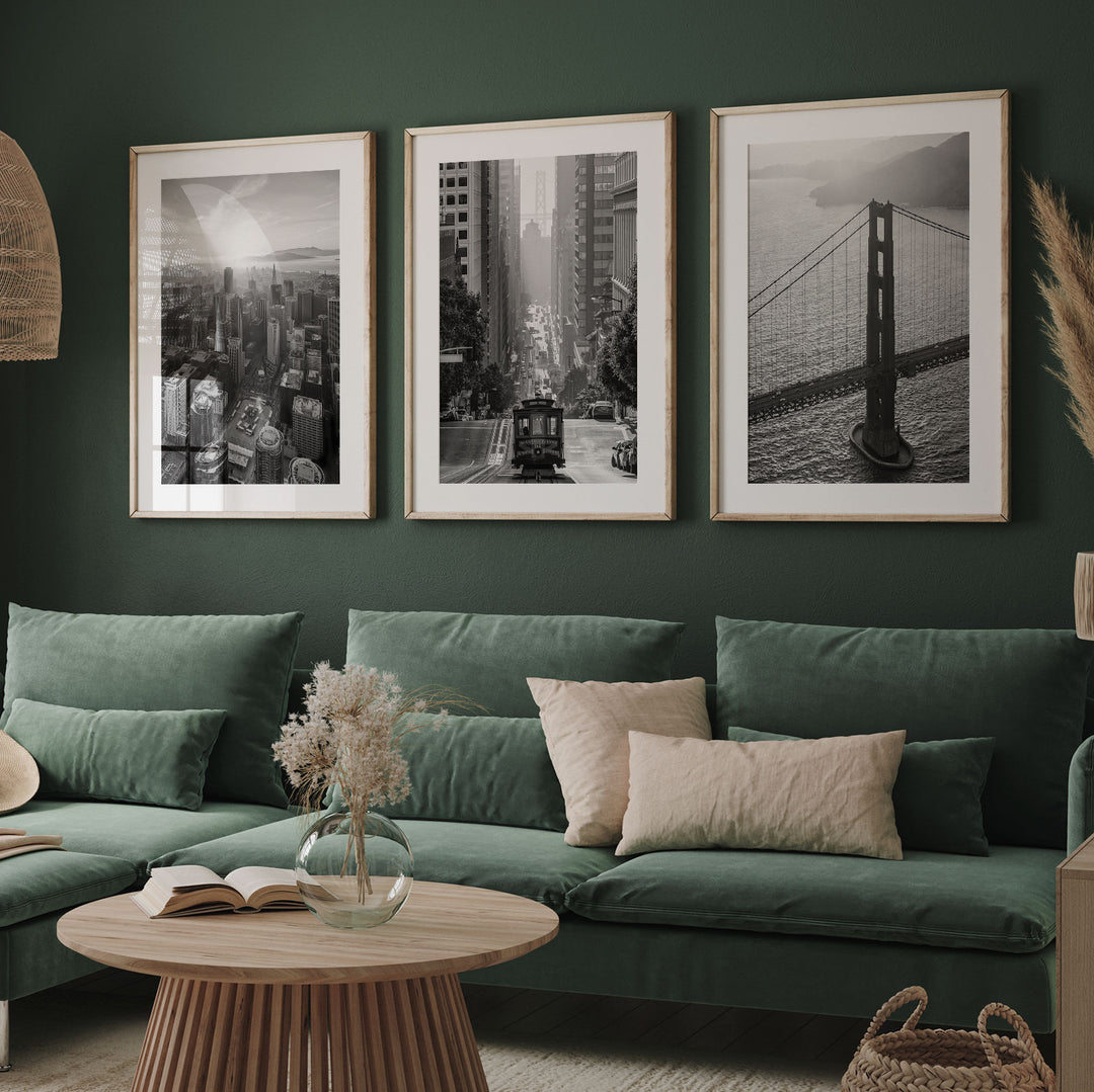 a living room with a green couch and two pictures on the wall