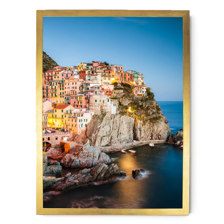 a picturesque coastal town nestled on a cliff, with its buildings painted in a variety of colors and illuminated by warm lighting, creating a vibrant and charming atmosphere.