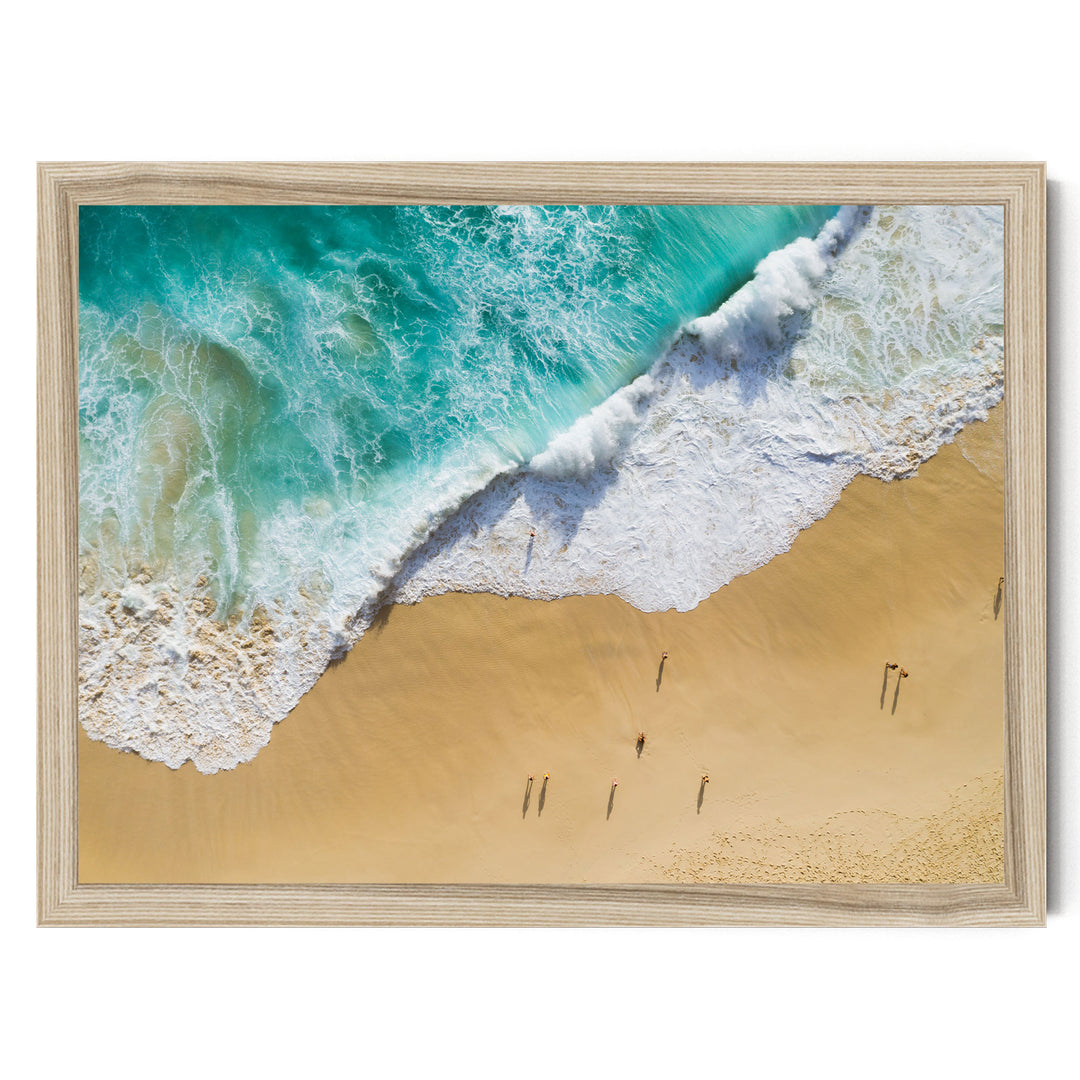 a serene beach scene with a large wave crashing onto the sandy shore, where a group of people are walking along the beach.