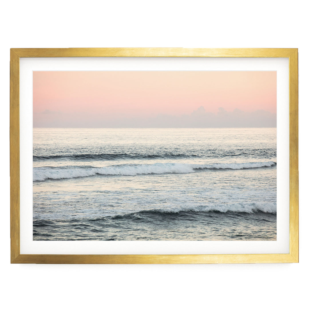 A serene ocean scene with waves gently lapping against the shore, framed in a gold frame.