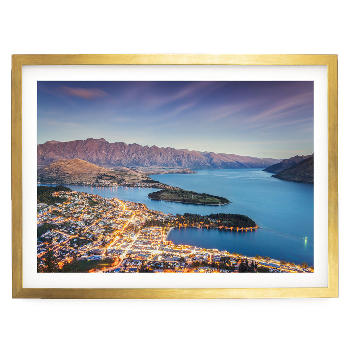 a picturesque cityscape nestled at the foot of a mountain range, with a stunning view of the city lights reflected in the calm waters of the lake or river.
