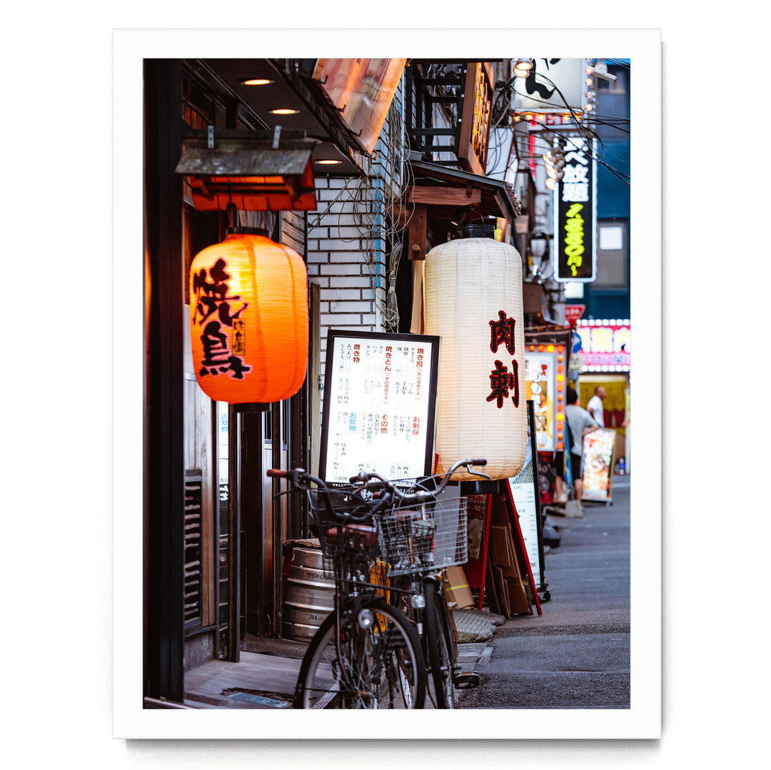 A bicycle parked on a street lined with colorful lanterns and signs, creating a vibrant and lively atmosphere.