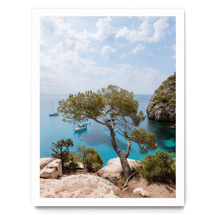 a serene coastal landscape with a rocky cliff overlooking a turquoise sea dotted with boats.