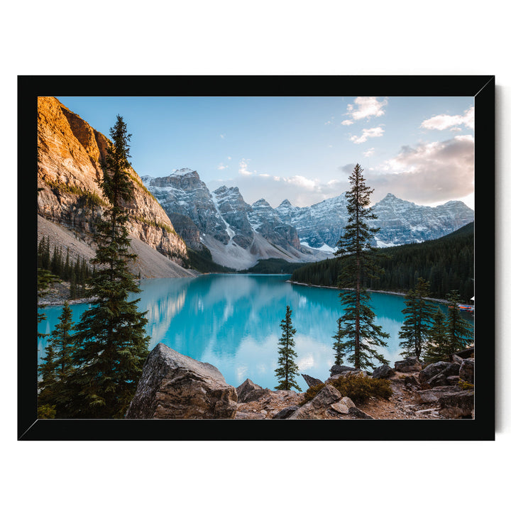 A breathtaking view of a serene mountain lake surrounded by towering peaks and lush forests, with a clear blue sky overhead.