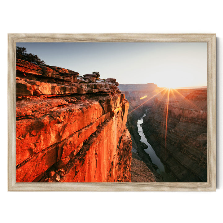a breathtaking view of a canyon with a river flowing through it, set against a stunning sunset sky.