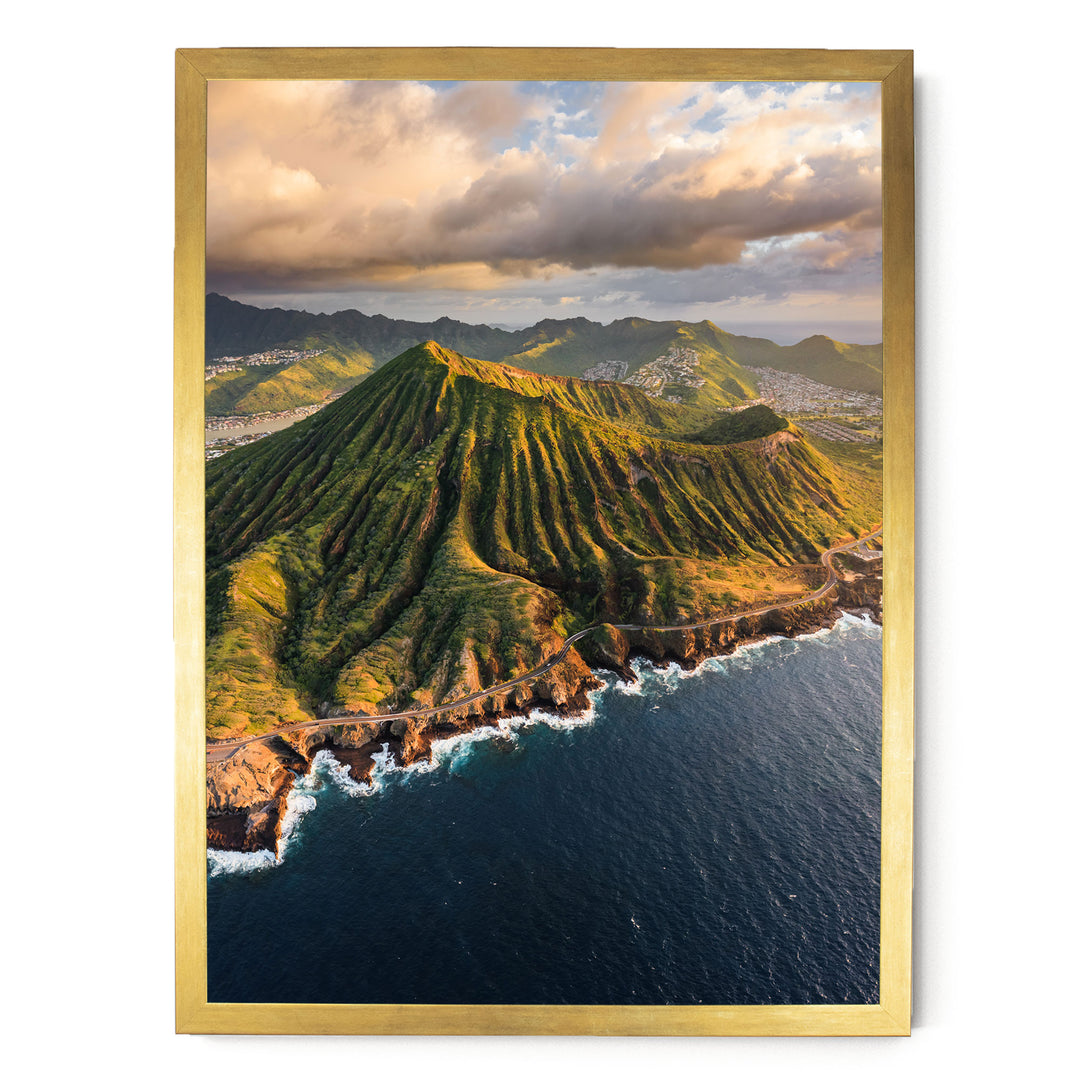 a stunning mountainous coastline with a winding road leading to the ocean. The landscape is covered in lush greenery, and the sky is filled with clouds, creating a dramatic backdrop. The overall scene is visually striking and captures the beauty of nature.