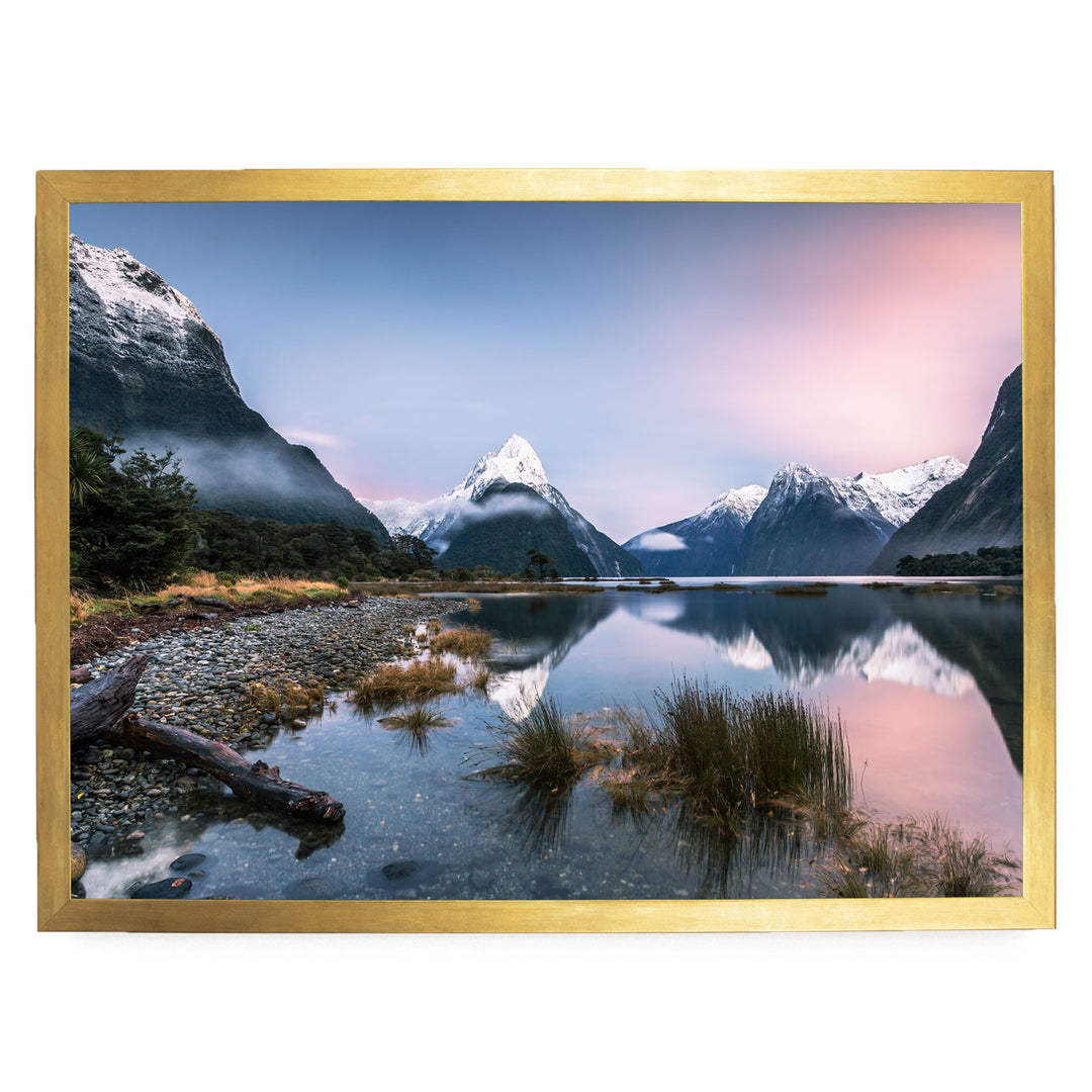 a serene landscape with a mountain range reflected in a calm lake, surrounded by lush vegetation and a clear blue sky.