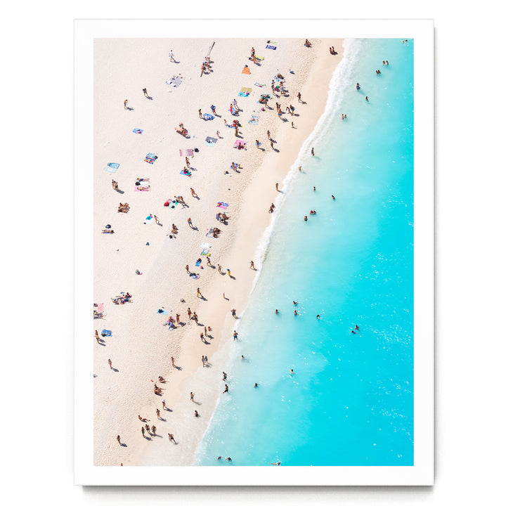 a crowded beach with many people enjoying the sunny day, with the ocean visible in the background.