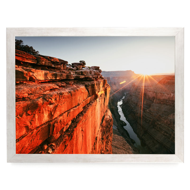 a breathtaking view of a canyon with a river flowing through it, set against a stunning sunset sky.