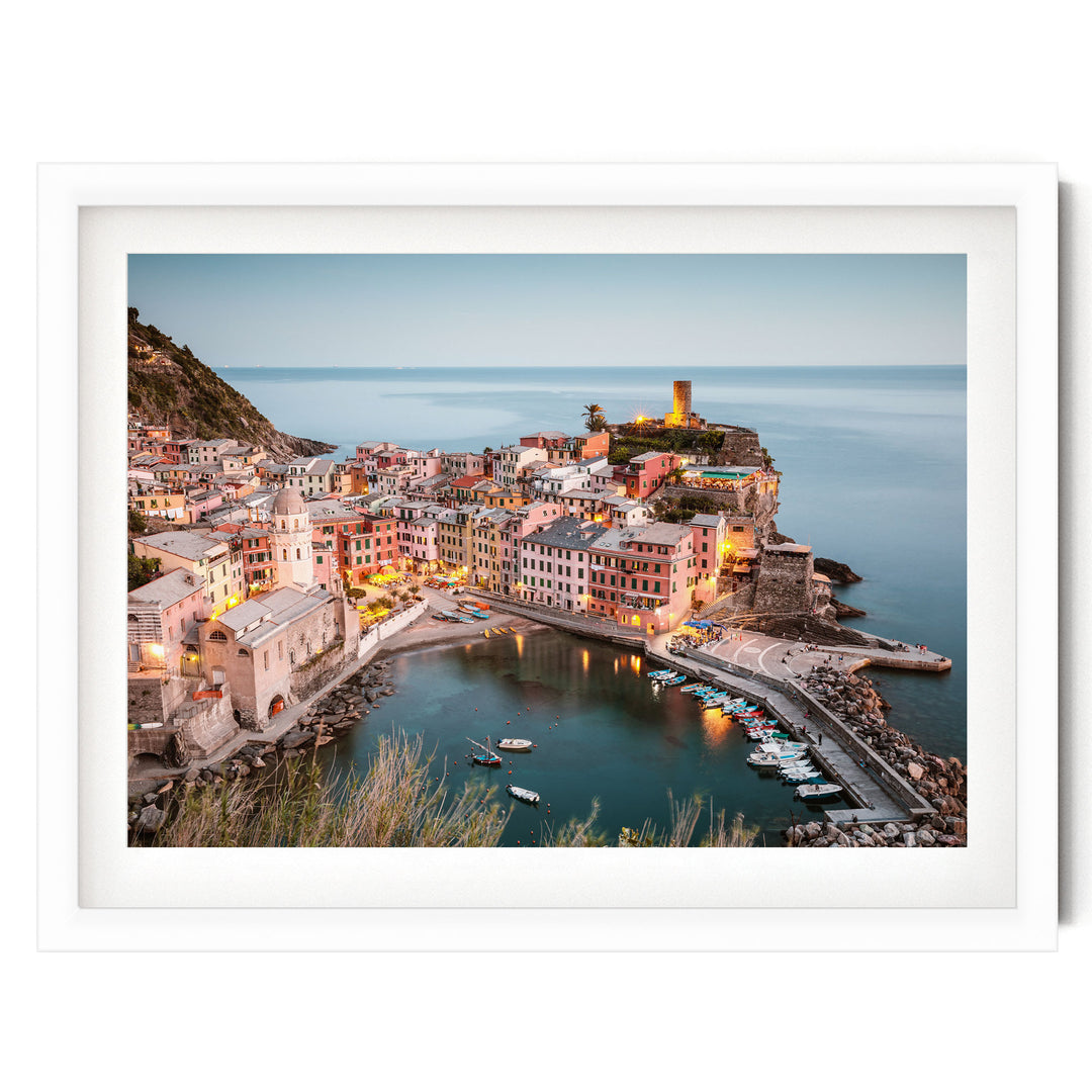 a picturesque coastal town with colorful buildings, a harbor filled with boats, and a lighthouse on a cliff overlooking the water.