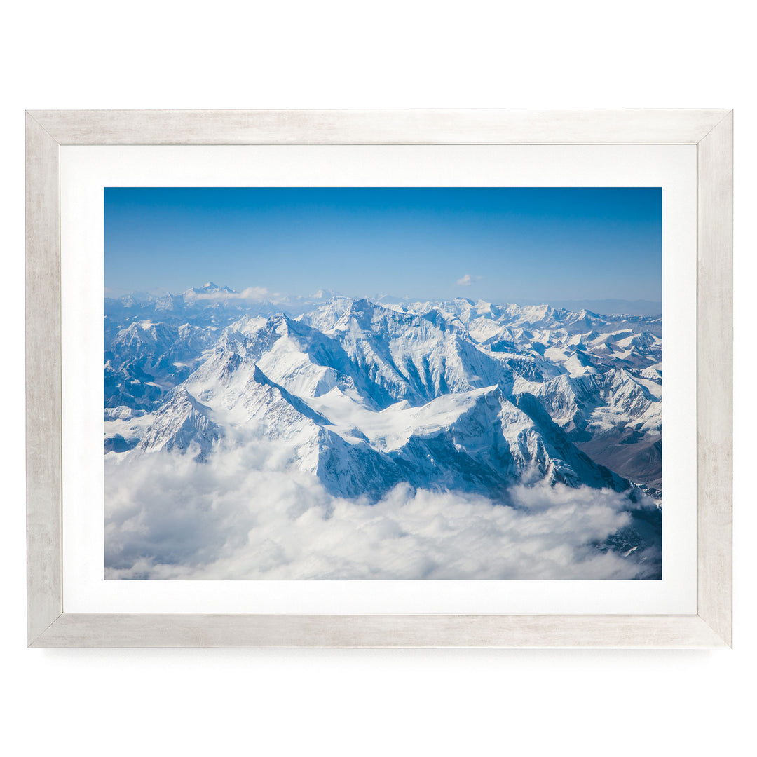 a breathtaking view of snow-capped mountains rising majestically from a sea of clouds, creating a stunning natural landscape.