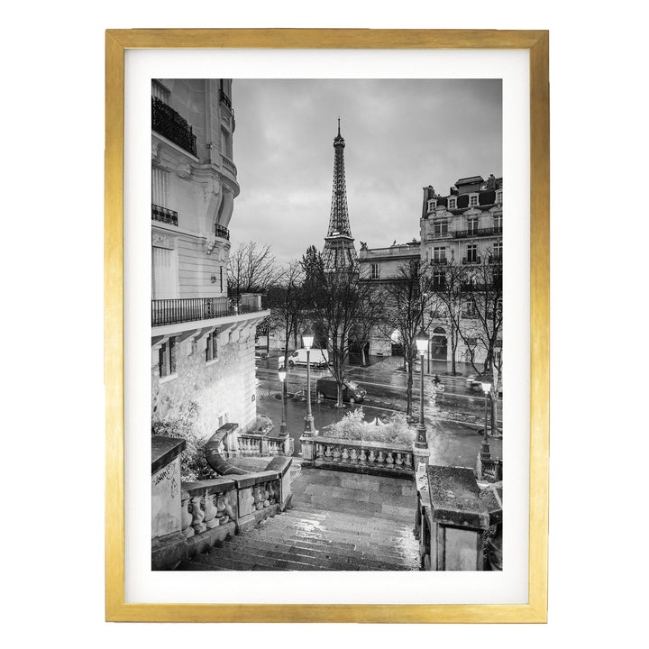 A black and white photograph of the Eiffel Tower in Paris, France, with a rainy cityscape in the background.