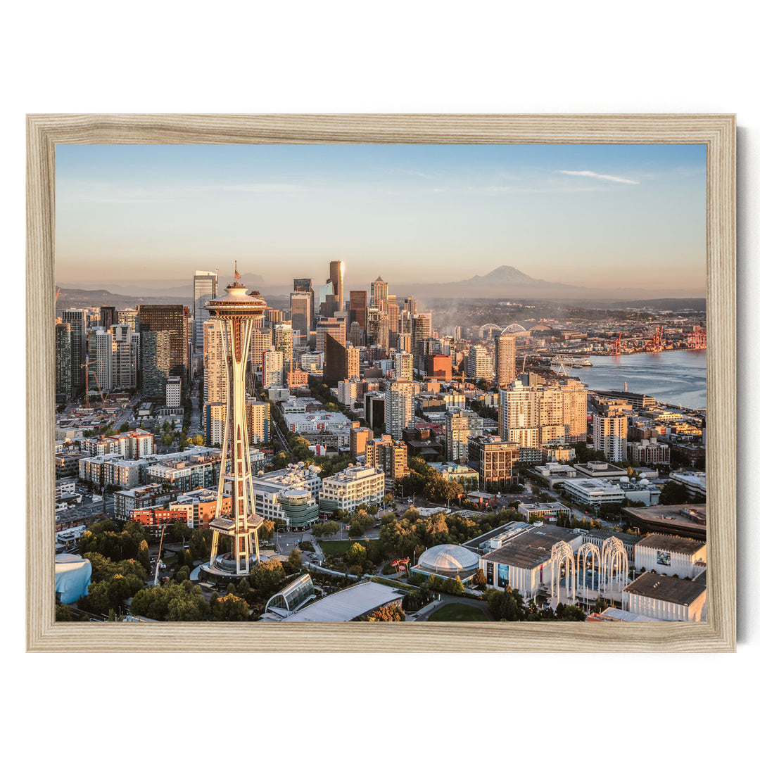 a cityscape with a tall tower, likely a landmark, surrounded by a variety of buildings and skyscrapers. The city appears to be at sunset, with the warm, golden light illuminating the scene.