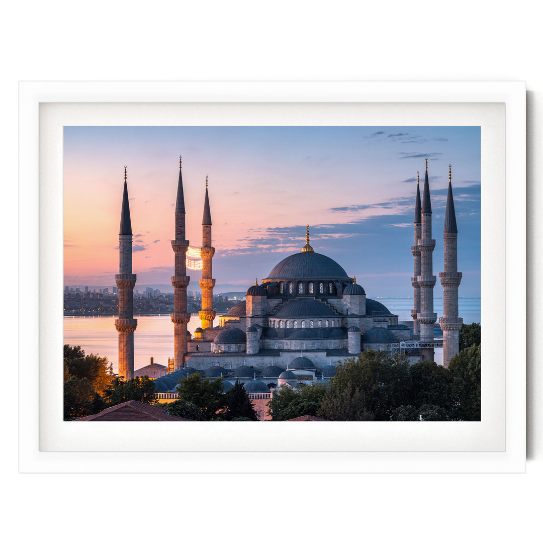 the Blue Mosque, also known as the Sultan Ahmed Mosque, in Istanbul, Turkey, with its distinctive minarets and domes silhouetted against a colorful sunset sky.