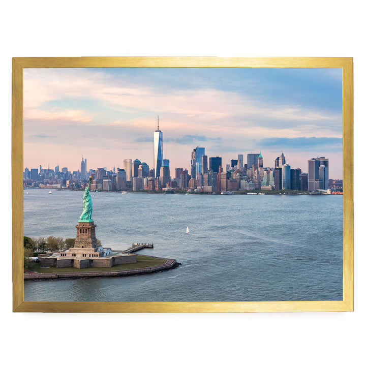 the Statue of Liberty on a small island in the foreground, with the New York City skyline in the background.