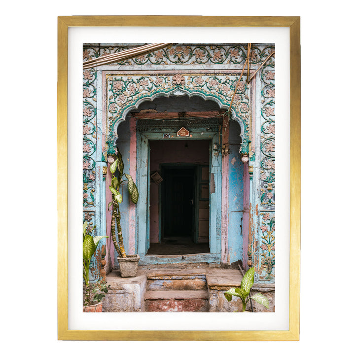 a colorful, ornately decorated doorway with a wooden frame. The doorway is adorned with intricate patterns and designs, and there are plants and other decorative elements surrounding the entrance.
