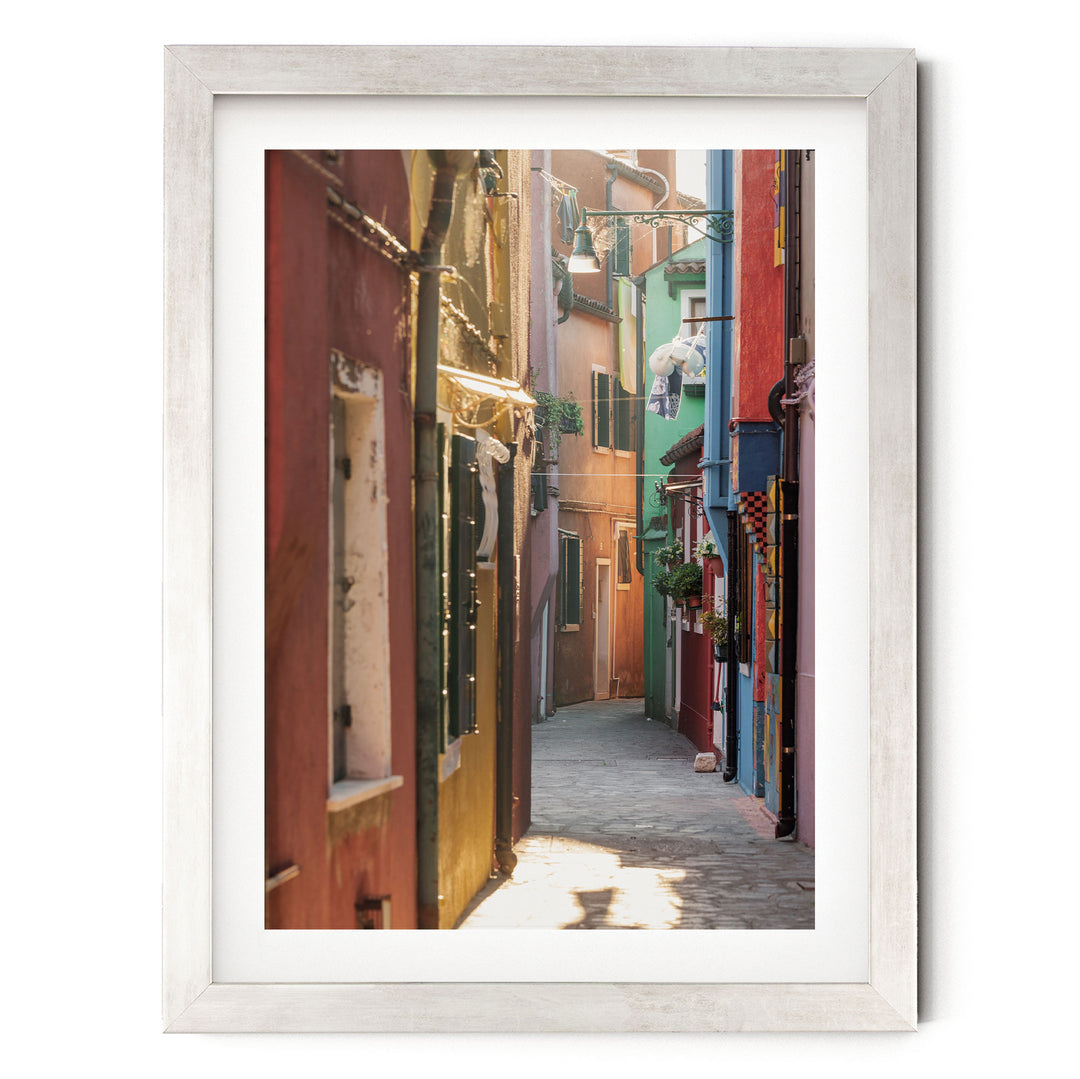 a narrow, colorful alleyway in a city, with buildings painted in various vibrant colors lining the street.